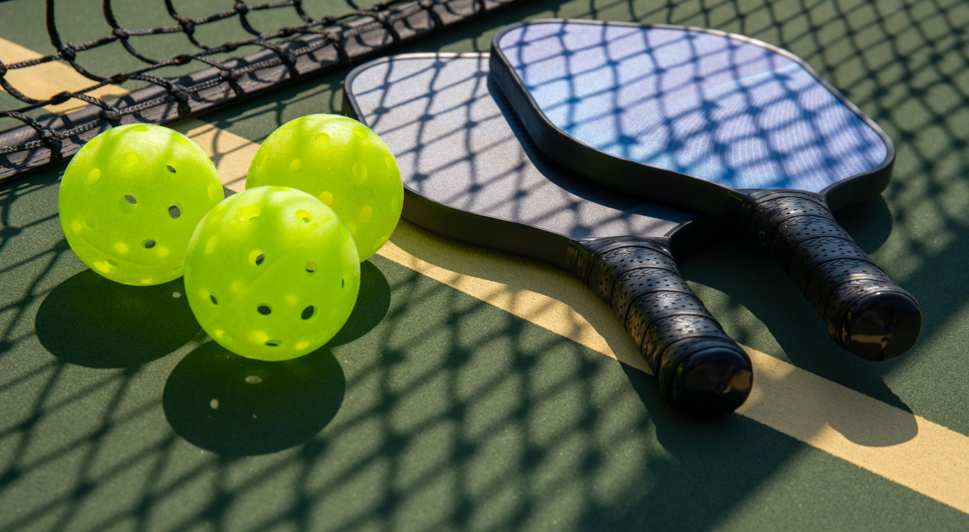 Pickleball paddles and balls on a court