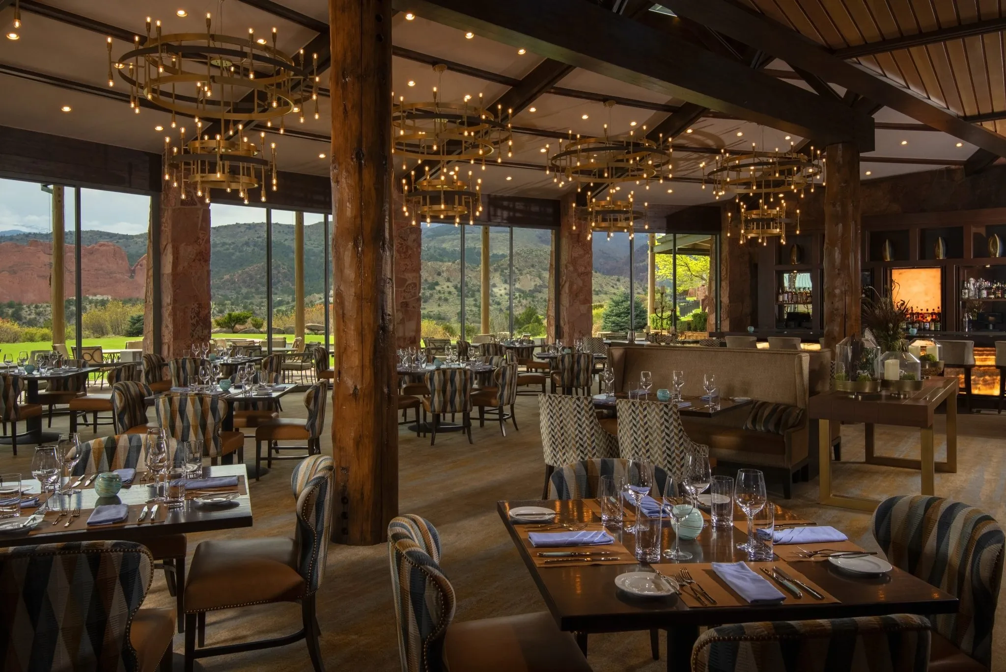 A dining room with a large window showing a mountain view.