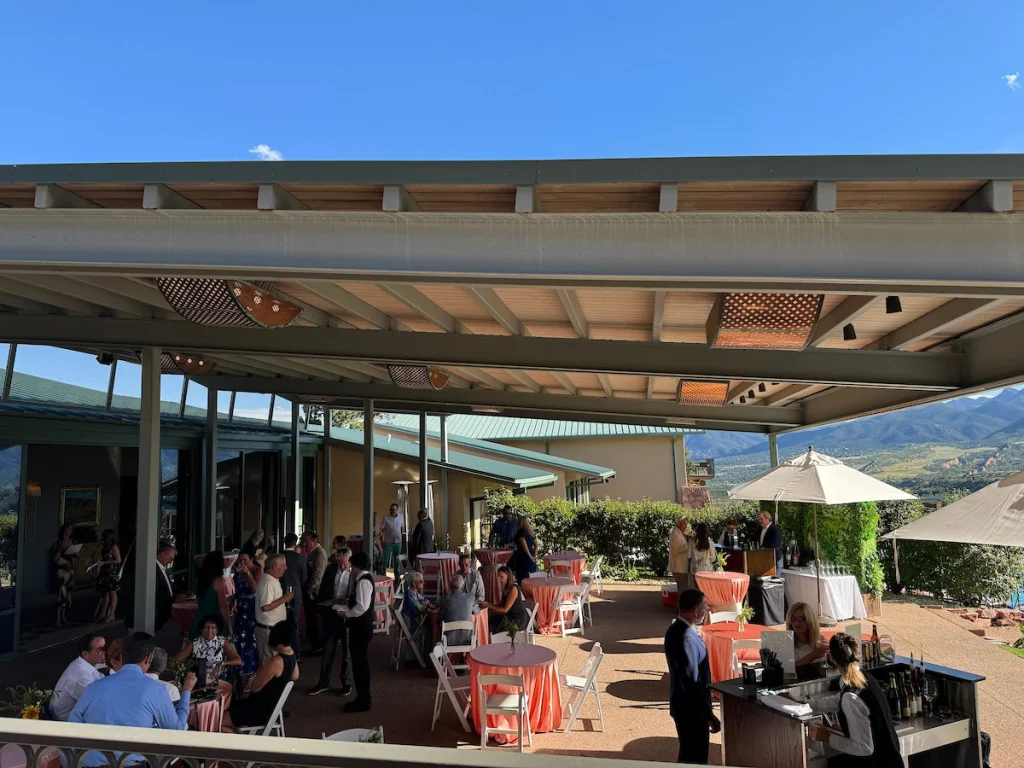 Guests mingling at an outdoor terrace cocktail reception for corporate company retreat ideas.