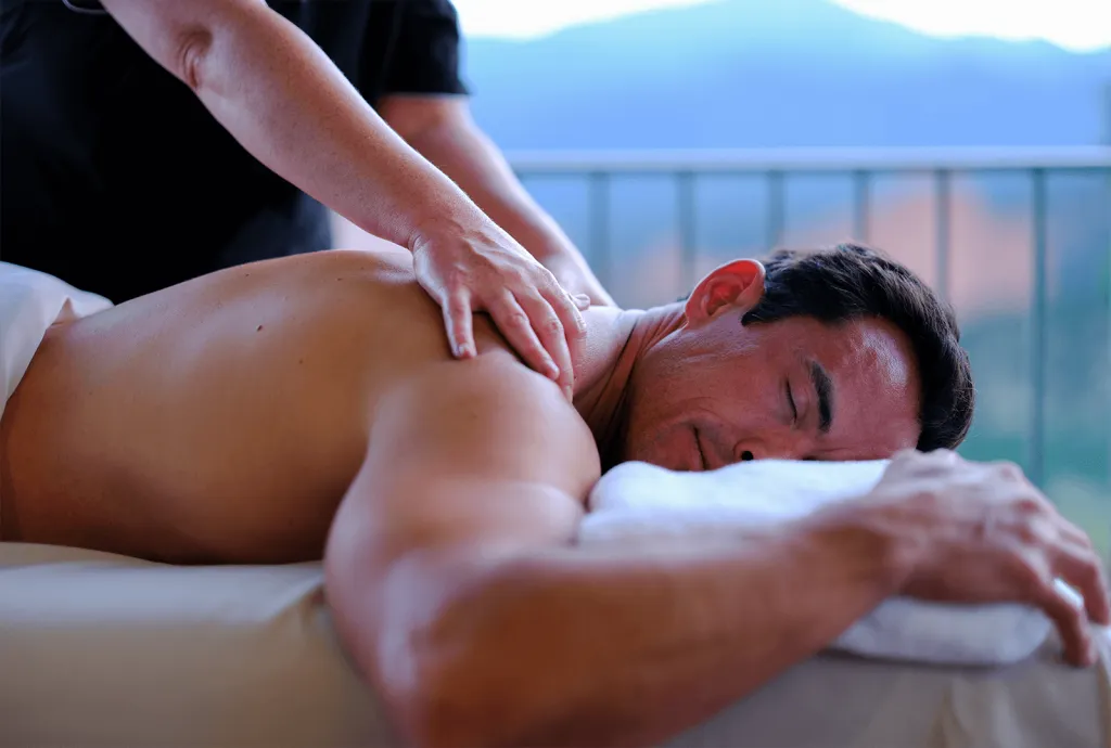 a man on a massage table getting a deep tissue massage at garden of the gods resort and club