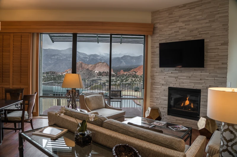 Modern resort living room with a fireplace and scenic mountain view through sliding glass doors